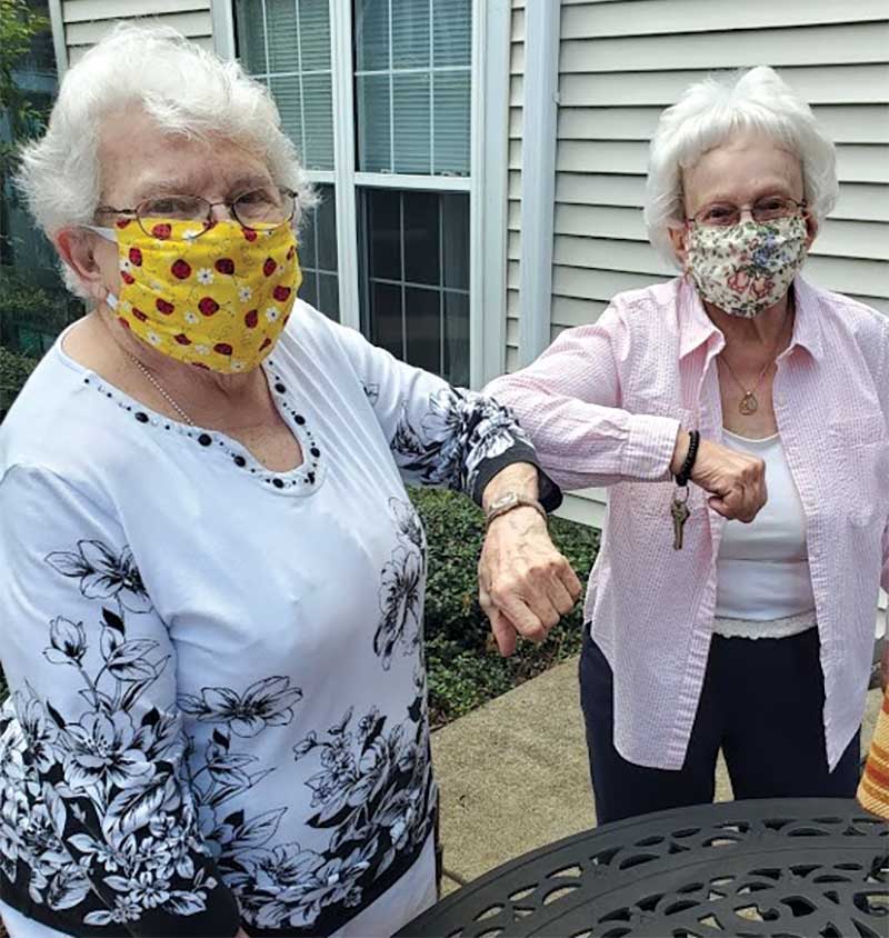 Seniors-in-Covid-Masks-elbow-bump Senior ladies wearing covid masks and elbow bumping