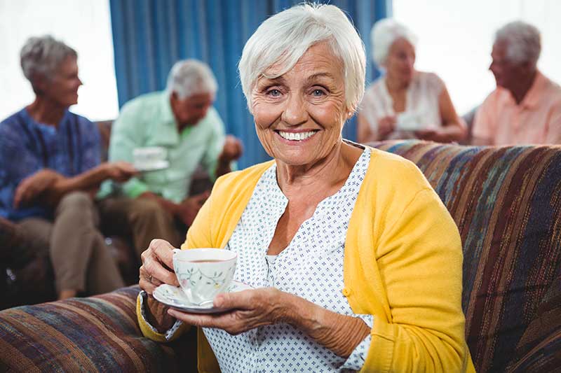 Senior woman smiling with a cup of coffee or tea