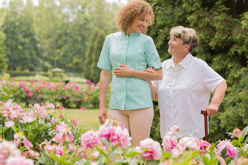 volunteer walking senior in garden