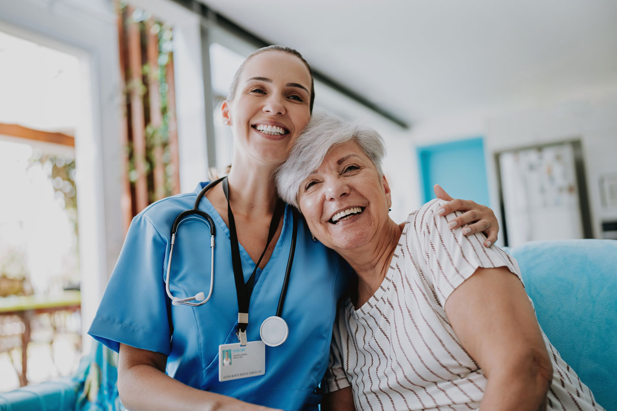 nurse hugging senior citizen