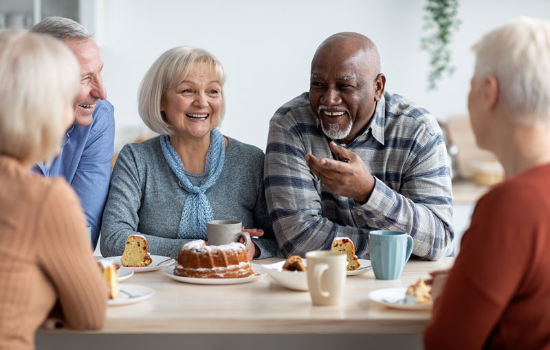 group of positive men and women sitting around coffee